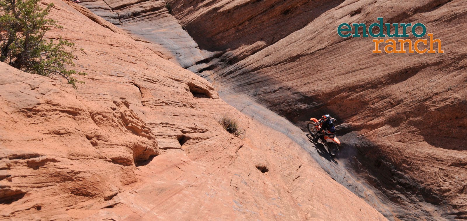 Enduro rider on solid rock shaped like a long V and going uphill in a spot called Hell's Gate.